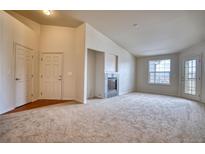 Bright living room features a fireplace, neutral carpeting, and access to the outside at 2875 Blue Sky Cir # 4-303, Erie, CO 80516