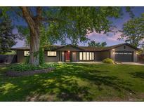 Charming home with a large tree, lush green lawn, and inviting red front door at 2180 Myrtlewood Ln, Lakewood, CO 80215