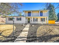 Charming two-story home features a welcoming front porch, manicured landscaping and a beautiful entry way at 3798 S Wabash St, Denver, CO 80237