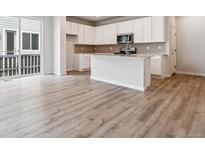 Modern kitchen features white cabinetry, stainless appliances, and island with breakfast bar seating at 14101 Deertrack Ln, Parker, CO 80134