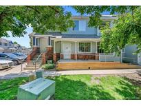 Charming townhome featuring a covered porch, brick accents, and well-manicured lawn at 12943 Lafayette St # F, Thornton, CO 80241