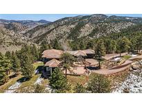 Luxury mountain home with tile roof, stone accents, and stunning views of the surrounding landscape at 290 Skyhill Dr, Evergreen, CO 80439
