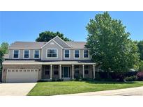 Charming two-story home features a welcoming front porch, lush lawn, and mature trees at 10512 Cimarron St, Longmont, CO 80504