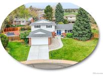 Charming two-story home with manicured lawn and attached two-car garage and an inviting blue door at 1860 E Geddes S Cir, Centennial, CO 80122