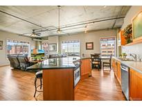 Open kitchen with island, wood cabinets, and stainless steel appliances at 1499 Blake St # 4O, Denver, CO 80202