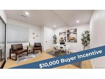 Bright home office featuring hardwood floors, modern decor, a white desk, and attractive art at 7932 E 49Th Pl, Denver, CO 80238