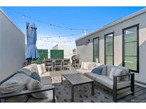 Spacious rooftop deck with comfortable seating, dining area, grill, and decorative greenery for outdoor enjoyment at 4263 E 8Th Ave, Denver, CO 80220