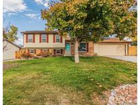 Charming two-story home with brick accents, a well-manicured lawn, and mature landscaping at 9510 Flower St, Broomfield, CO 80021