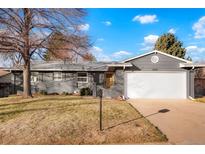 Ranch style home with gray exterior, landscaped lawn, and attached garage at 4751 S Xenia St, Denver, CO 80237