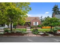 Charming brick home with a well-maintained front yard and beautiful landscaping in a suburban neighborhood at 1429 Hudson St, Denver, CO 80220