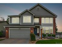 Charming two-story home showcasing gray siding, brick accents, and well-maintained landscaping at 20710 E Princeton Pl, Aurora, CO 80013