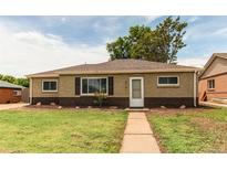 Charming single-story home features classic brickwork, manicured lawn, and inviting pathway to front door at 9141 Gail Ct, Thornton, CO 80229