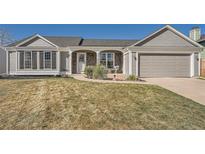 Charming ranch style home with stone accents, gray siding, and a well-maintained lawn at 21585 E Powers Cir, Centennial, CO 80015
