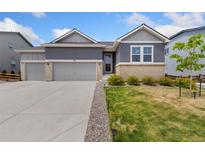 Charming gray two-story home with a two car garage and well-manicured lawn at 113 Marlowe Dr, Erie, CO 80516