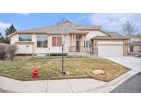 Two-story house with attached garage, landscaping, and a front yard at 3275 S Indiana St, Lakewood, CO 80228