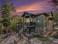 Stylish home featuring a deck, stone accents, and a picturesque hillside setting at 12261 Hosman Ct, Conifer, CO 80433
