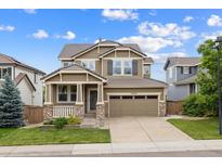 Charming two-story home boasts a landscaped yard, covered porch, and a two-car garage with ample parking space at 10535 Laurelglen Cir, Highlands Ranch, CO 80130