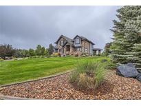 Stunning two-story stone house with well-manicured lawn and mature trees at 15102 Prairie Pl, Broomfield, CO 80023