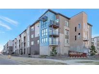 Modern condo building with balconies, brick accents, and professional landscaping at 400 E Fremont Pl # 207, Centennial, CO 80122