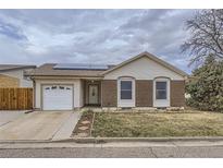 Charming home featuring a brick facade, vinyl siding, solar panels, and a well-kept front lawn at 427 Hickory St, Broomfield, CO 80020