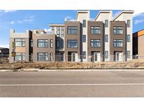 Modern townhomes featuring large windows, brick accents, and a contemporary design at 6959 E Lowry Blvd, Denver, CO 80230