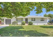 Charming brick home with a well-manicured lawn, established landscaping, and an attached garage at 366 Kenton St, Aurora, CO 80010