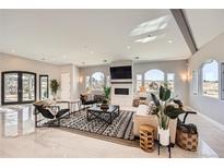 Spacious living room with large windows, fireplace, and stylish furnishings at 3250 Via Margarita, Castle Rock, CO 80109