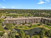 Expansive aerial view of community showcasing lush greenery, water feature, and multi-story buildings at 7000 E Quincy Ave # 302, Denver, CO 80237