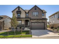 Charming two-story home featuring stone accents, a covered porch, and an attached two-car garage at 747 Raindance St, Erie, CO 80516