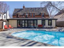 Backyard pool and outdoor living area of brick two-story home with full wall of glass doors at 629 Bellaire St, Denver, CO 80220