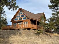 A-frame cabin with large windows and wrap-around deck at 4924 S Indian Trl, Evergreen, CO 80439