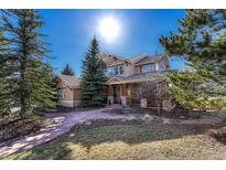 Beautiful home exterior with a well-manicured lawn, mature trees and a stone walkway at 3125 Starling Ct, Castle Rock, CO 80109
