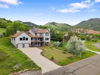 Stunning two-story home with a well-manicured lawn and a mountain backdrop at 5979 Willow Springs Dr, Morrison, CO 80465