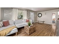 Bright living room with hardwood floors, white sofa and decorative accents, creating a cozy atmosphere at 4051 S Cherokee St, Englewood, CO 80110