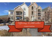 Inviting condo building with stone accents, balconies, and well-maintained landscaping, offering a $5,000 seller concession at 19049 E Warren Dr # 105, Aurora, CO 80013