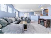 Spacious living room featuring plush gray sectional sofa, neutral carpet, and a cozy fireplace at 9311 Amison Cir # 201, Parker, CO 80134