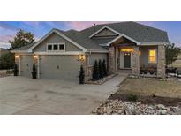 Beautiful two-story home featuring a three-car garage, stone accents, and professionally landscaped front yard at 1658 Glade Gulch Rd, Castle Rock, CO 80104
