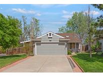 Charming home featuring a gray exterior, well-manicured lawn, and an attached two-car garage at 5566 S Zinnia St, Littleton, CO 80127