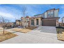 Charming two-story home featuring a stone-accented facade, covered entry, spacious driveway, and well-maintained landscaping at 18220 W 84Th Pl, Arvada, CO 80007