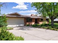 Charming brick home with a two-car garage, mature trees, and a spacious driveway at 962 S Beech St, Lakewood, CO 80228