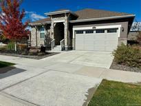 Single-story home with attached garage, stone accents, and landscaping at 8885 S Tibet Ct, Aurora, CO 80016