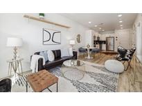 Comfortable living room featuring modern decor, a stylish rug, and a sleek leather sofa at 2851 W 52Nd Ave # 208, Denver, CO 80221
