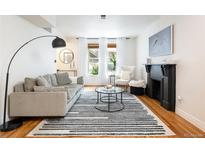 Bright living room features a fireplace, large windows, and stylish furnishings at 1415 E 16Th Ave # 1/2, Denver, CO 80218