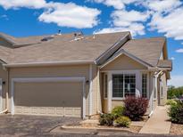 Charming tan townhouse with attached garage, neat landscaping, and sunny skies at 12335 E 2Nd Dr, Aurora, CO 80011