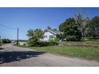 Charming single-story home with blue siding and mature trees surrounding the property at 6597 S State Highway 83, Franktown, CO 80116
