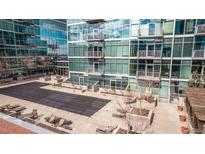 Rooftop pool deck and patio area with lounge chairs at modern condo building with glass facade at 1700 Bassett St # 820, Denver, CO 80202