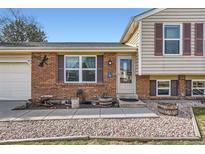 Charming home featuring a brick facade, decorative shutters, and a welcoming front entrance at 7153 S Cody Cir, Littleton, CO 80128