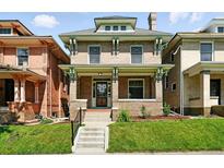 Charming brick two-story home with a manicured front lawn and inviting front porch at 1582 Steele St, Denver, CO 80206