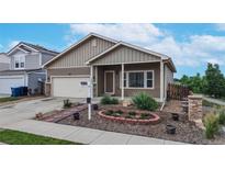 Charming home showcasing a manicured front yard and an inviting covered porch entrance with well-maintained landscaping at 169 Westin Ave, Brighton, CO 80603