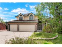 Charming two-story home with a brick facade and attached two-car garage at 15916 E Crestridge Pl, Centennial, CO 80015